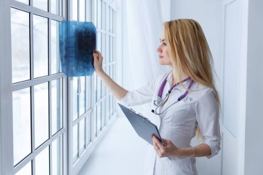 Genç profesyonel kadın doktor bir ziyaret sırasında hastanın x-ray insan omurga incelenmesi