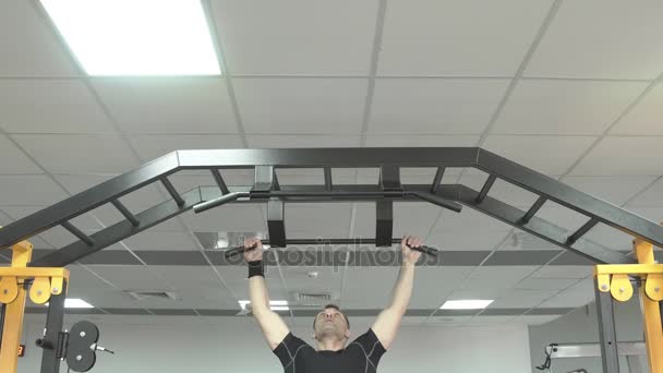 Homme fort faisant des pull-ups dans une salle de gym — Video