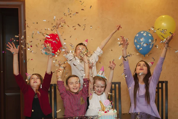 Kinder werfen Konfetti auf ein Kinderfest. Kinder haben gemeinsam Spaß im Familienurlaub. — Stockfoto