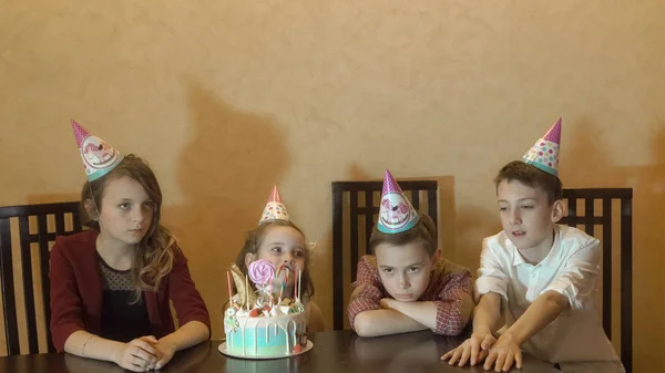 Niños aburridos en la fiesta de cumpleaños. pastel de cumpleaños para niña de cumpleaños —  Fotos de Stock