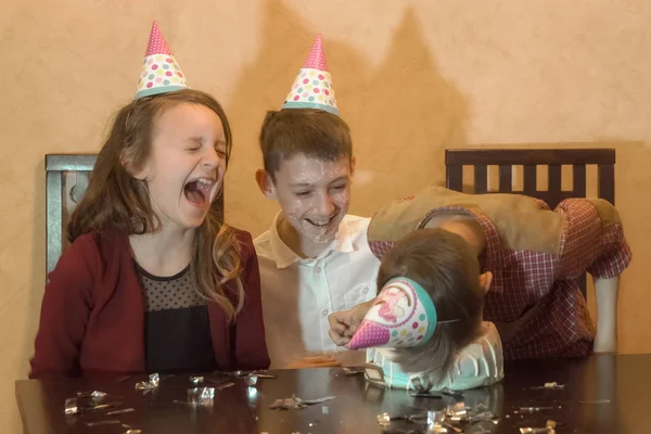 Bambini spensierati a una festa di compleanno. faccia del bambino nella torta di compleanno — Foto Stock