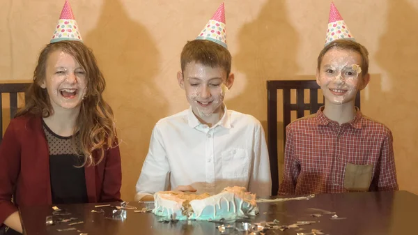 Bambini spensierati a una festa di compleanno. faccia di bambino è nella torta e sorridente — Foto Stock