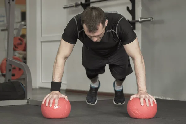 Muž fitness cvičením kliků na míč v tělocvičně — Stock fotografie