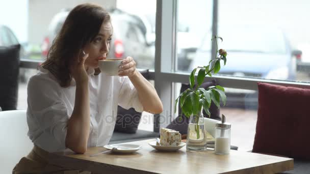 Jovem bebendo café e falando no celular no café. mulher de negócios na pausa para almoço — Vídeo de Stock