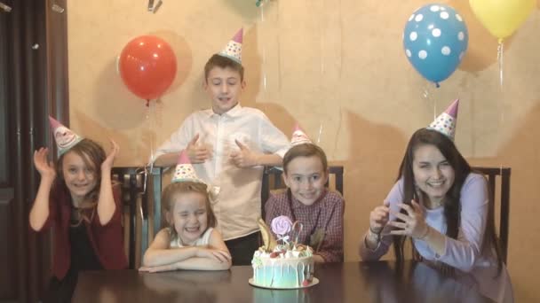 En grupp barn i holiday mössor på barnens fest. Barnen har roligt tillsammans på en familjesemester. Slow motion — Stockvideo