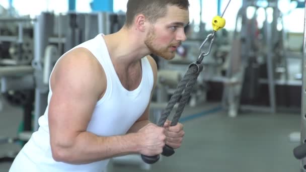 Hombre atlético fuerte n una camiseta en el entrenamiento de gimnasio en el dispositivo de bloque. Entrenamiento Crossfit — Vídeo de stock