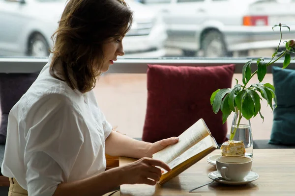 Dziewczyna, czytanie książki i zrelaksować się w kawiarni. Dziewczyna w ubrania biznesowe, odpoczynek w trakcie przerwy na lunch — Zdjęcie stockowe