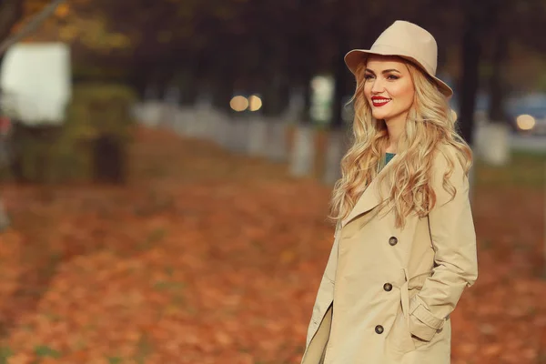 Gadis cantik muda dengan topi krem dan mantel di taman di musim gugur . — Stok Foto