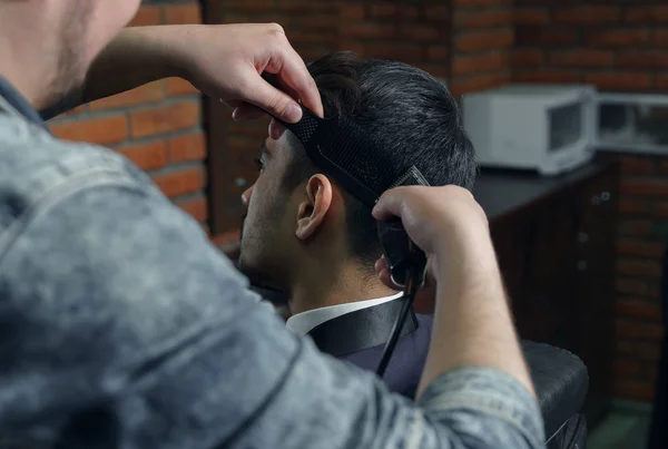 Side view of man in suit getting haircut by hairdresser at the barbershop — Stock Photo, Image