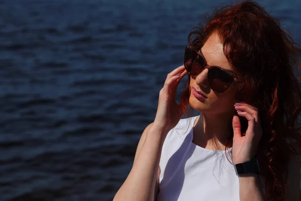 Женщина в белом платье и солнечных очках на открытом воздухе — стоковое фото
