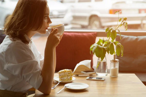 여자는 향기로운 커피와 달콤한 케이크 카페에 앉아 즐긴다. 비즈니스 여자 휴식 중 휴식 — 스톡 사진