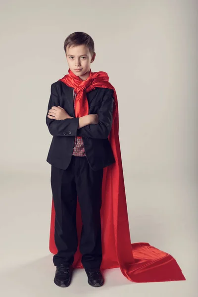 Genç iş çocuk takım elbise ve kırmızı süper kahraman pelerinli — Stok fotoğraf