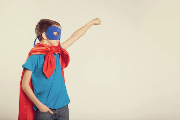 El pequeño superhéroe disfrazado levantó la mano. espacio de copia, tonificado . — Foto de Stock