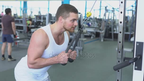 Portrait of strong athletic man at the gym training on block device — Stok Video