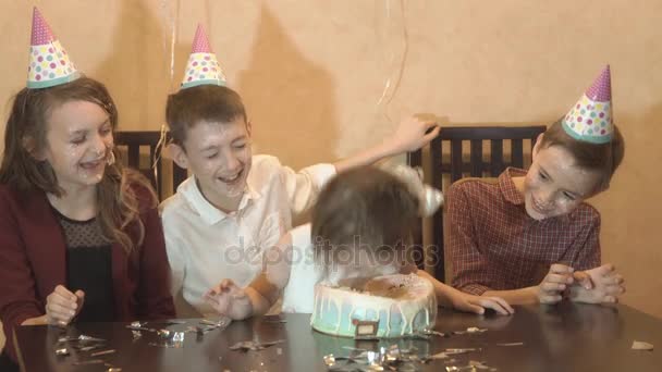 Enfants insouciants à une fête d'anniversaire. amis trempé anniversaire fille visage dans le gâteau d'anniversaire — Video