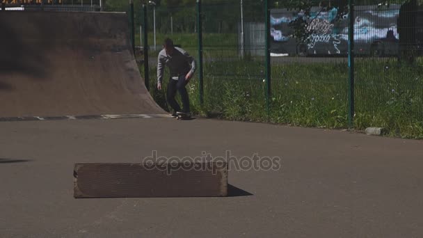 Молодой человек учится кататься на скейтборде падает в скейт-парке — стоковое видео