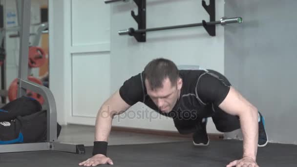 Hombre de fitness haciendo palmas flexiones ejercicio intenso entrenamiento en el gimnasio — Vídeos de Stock