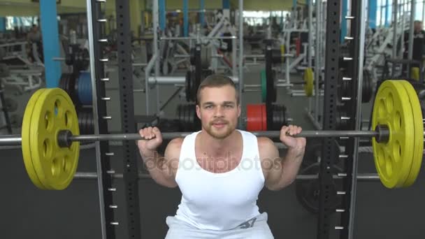 Entraînement de force dans la salle de gym. Il fait des squats avec un haltère. bodybuilder faire l'exercice avec haltère — Video