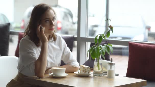 Junges schönes Mädchen trinkt Kaffee in einem Café — Stockvideo