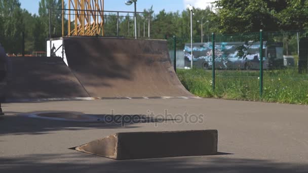 Молодий чоловік стрибає на скейтборді в скейт-парку . — стокове відео