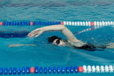 Genç kız gözlük ve gezinme kontur stili mavi su havuzda kap.