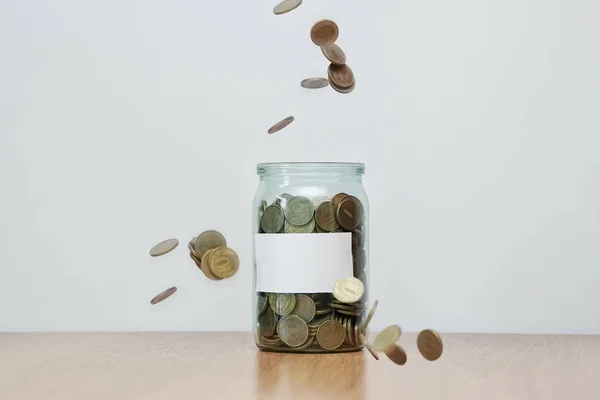 Skleněná dóza plná padajících mincí, prázdná nálepka, Pokladnička. Hotovost nebo penny úspory — Stock fotografie