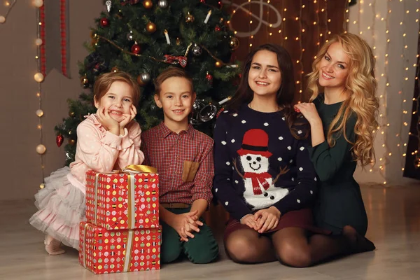 Feliz familia madre e hijos en Navidad en el árbol de Navidad con regalos — Foto de Stock