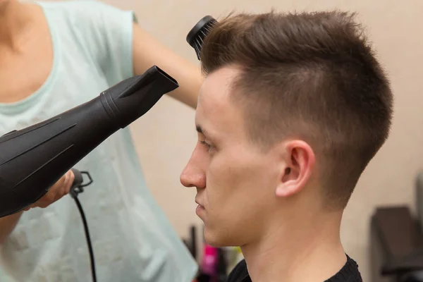 Zbliżenie na kobiece Fryzjer suszenia włosów jej mężczyzna klienta w jej salon fryzjerski — Zdjęcie stockowe