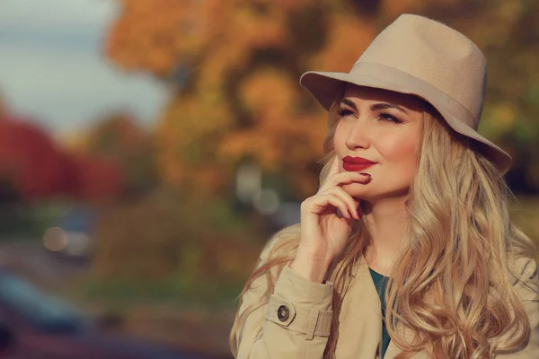 Красивая женщина думает на фоне желтого кленового сада. close up fashionable girl, — стоковое фото