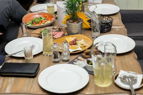 Una cena amistosa. grupo de personas cenando juntas mientras están sentadas en la mesa de madera —  Fotos de Stock
