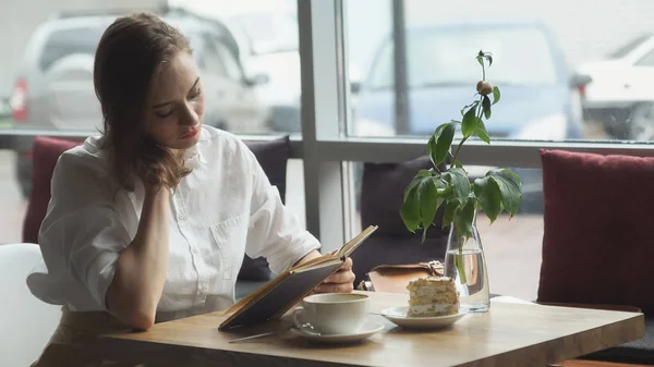 Flicka läsa bok och koppla av i kaféet. flicka i business kläder vila under lunchrasten — Stockfoto