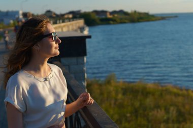 Genç kız gözlük günbatımı Rıhtımlar üzerinde sahiptir..