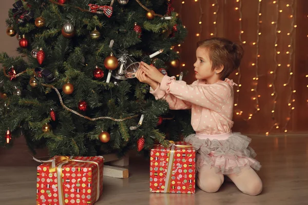 Chica decorar el árbol de Navidad en el interior de una casa — Foto de Stock
