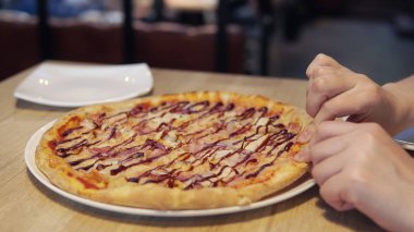 Pizza alarak kadının elleri kafede dilim