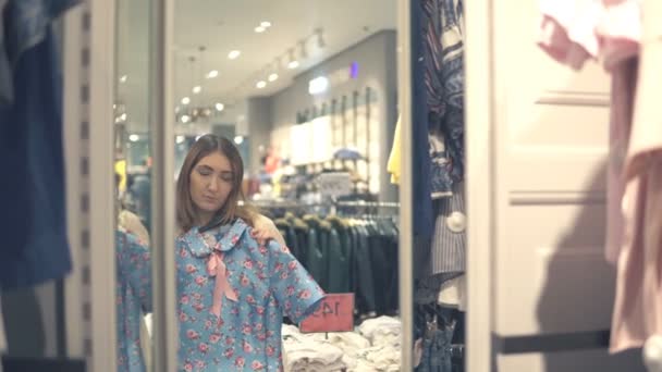 幸せなアジア女の服を選ぶとモールや衣料品店でミラーを — ストック動画