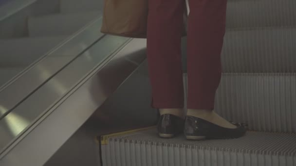 Chica en la escalera mecánica. Teléfono que sobresale de la bolsa — Vídeos de Stock