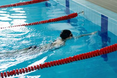 Genç kız gözlük ve gezinme kontur stili mavi su havuzda kap.