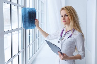 Genç kadın doktor stetoskop ve x-ışını ile portresi