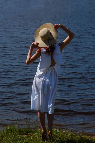 Ženská osoba v bílých šatech a klobouk na riverside — Stock fotografie