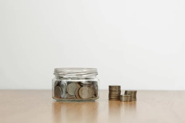 Skleněný džbán plný mincí a zásobníku penny — Stock fotografie