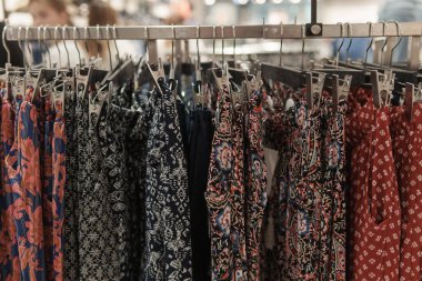 Giysiler tasarımcı giyim mağazasının rafında asılı.