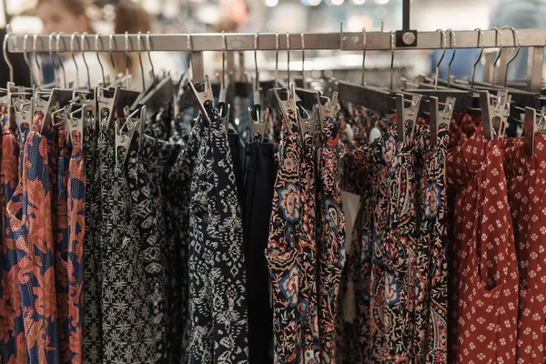 Giysiler tasarımcı giyim mağazasının rafında asılı.