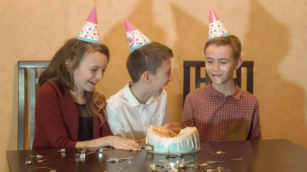 Kaygısız çocuk bir doğum günü partisinde. doğum günü pastası çocuğun yüzüne — Stok fotoğraf