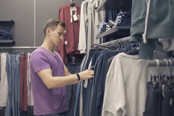 Genç adam giyim mağazası giysilerle arıyor