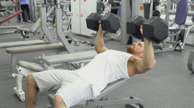 Göğüs dumbbells ile egzersiz yaparak atlet. jimnastik salonu kas delikanlı trenler.
