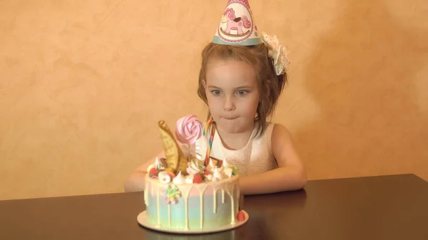 Fiesta de cumpleaños de los niños. Niña mirando el pastel. concepto de feliz cumpleaños —  Fotos de Stock