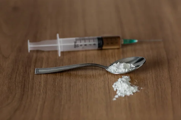 Cuillère avec cocaïne et seringue sur la table en bois.. Concept arrêter la toxicomanie — Photo