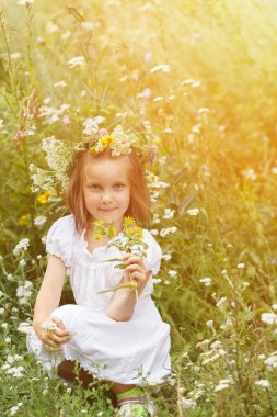 Çocuk beyaz elbise ve çiçek çelenk