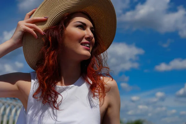 Улыбающаяся женщина с красивыми рыжими волосами в шляпе — стоковое фото