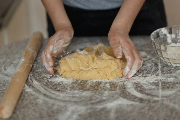 Пекарь месит тесто в муке на столе — стоковое фото